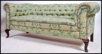 An Edwardian Chesterfield sofa settee being raised