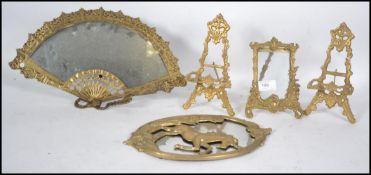 A collection of 19th and 20th century brass ware to include a unicorn mirror, an easel back fan