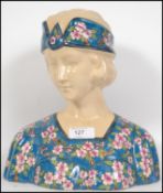 A large 20th century ceramic Longwy Art Deco style bust of a maiden with chintz pattern blouse.