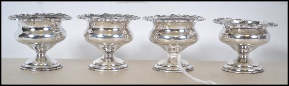 A set of 4 silver hallmarked egg cups of rococo form being hallmarked for A&Co - Asprey's of London.