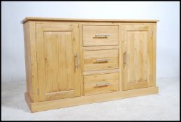 A contemporary light oak sideboard fitted with three drawers and two cabinets