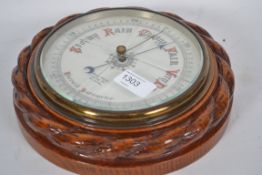 A  1920's oak cased wall barometer having ceramic face with retailers notation for Kemp Bros