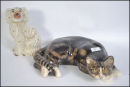 A 20th century Kensington pottery recumbent Tabby cat by Winstanley marked to base together with a