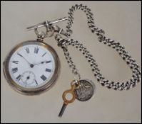 A silver hallmarked open faced pocket watch with heavy linked albert chain, t-bar and fob. The key