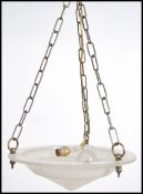 A contemporary 20th century ceiling light having three brass chain links with a circular convex