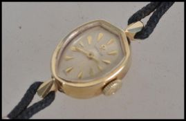 A ladies vintage 20th century Omega cocktail watch with an armorial shield shape dial with batons on