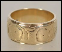 A hallmarked 9ct gold band ring having chased decoration. Bearing Birmingham assay marks, marked