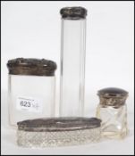 A collection of vintage glass dressing table items with silver hallmarked tops to include a