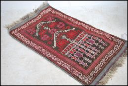 An early 20th century hand knotted vintage Turkish prayer rug on red ground having central mihrab