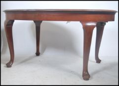 An Edwardian mahogany 3 leaf extending dining table being raised on cabriole legs with pad feet