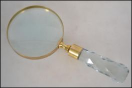 A large 20th century desk top magnifying glass with brass rim having a faceted cut glass handle.