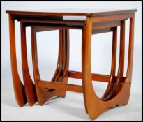 A 1970's retro Danish influence teak wood nest of tables raised on pierced chamfered edge supports
