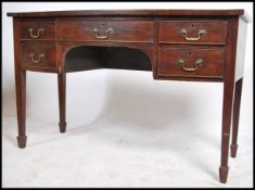 A Georgian revival early 20th century mahogany bow front writing table desk raised on squared legs