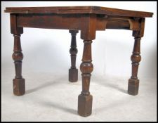 An early to mid 20th century 1940's oak draw leaf dining tadle raised on block and turned legs