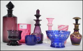 A collection of vintage glass dating from the 19th century to include purple decanters, blue glass