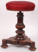 A William IV mahogany revolving piano stool having trefoil base with baluster column and revolving