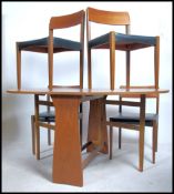 A retro 20th century set of four teak wood dining chairs having black vinyl seat pads together
