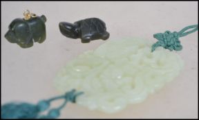 A collection of Chinese carved Jade pieces .  A large pendant carved with scrolls and flora's with a