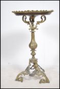 A 19th century French continental Empire mahogany and gilt metal tripod wine table The pierced brass