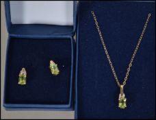 A Demi Parure 9ct gold and peridot set pendant necklace and chain set. Fine linked chain with oval