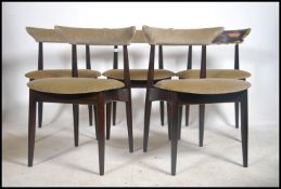 A set of 5 mid century cow horn backed dining chairs in the manner of Hans Wegner being raised on