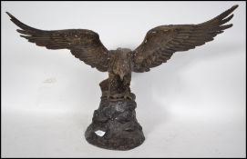 A large 20th century bronze hollow cast statue of an Eagle with wings at full span and being upon