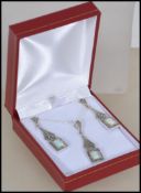 A ladies Art Deco Demi Parure necklace and earrings set adorned with opals and surrounded by