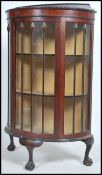 An Edwardian mahogany demi-lune half moon china display cabinet raised on claw and ball feet with