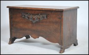 A 19th century oak suffolk style country coffer of small form with carved panel front having