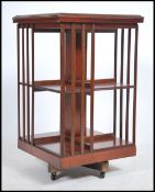 An Edwardian mahogany inlaid revolving bookcase having slatted form with section revolving