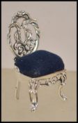 A silver pin cushion in the form of a Thomas Chippendale chair having blue baize cushion to the