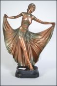 A 1930's Art Deco plaster figurine of a dancing lady being raised on a plinth base with inscribed RD