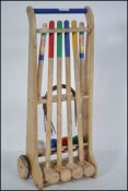 A mid 20th century child's garden Croquet set, set within a frame set on wheels to include