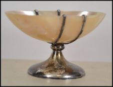 A silver hallmarked mother of pearl salt. A mother of pearl bowl raised on a pedestal silver base.