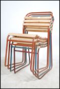A stack of vintage mid century Industrial / school hall stacking chairs being raised on tubular