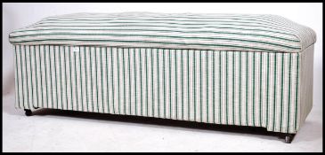 A large early 20th century linen lined ottoman of rectangular form having button backed cushion