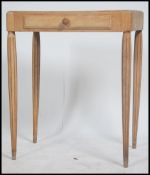 A 1930's Art Deco stripped oak French writing table desk being raised on reeded baluster legs with