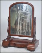 A Victorian large flame mahogany toilet dressing table mirror raised on a shaped plinth base with