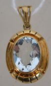 A 14ct / 585 gold and aquamarine pendant of oval cut to centre with bale atop. Marked 585. Total
