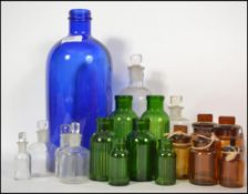 A collection of vintage blue and green glass Apothecary bottles dating back to the early 20th