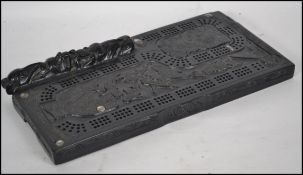 A cribbage board in the Haida native american style with totemic decoration and haliotis shell