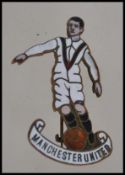 A rare 1920's enamel pin badge for Manchester United. In the form of a footballer having mark to