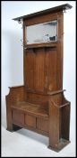 A large early 20th century oak hall stand settle.