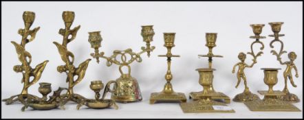 A collection of 19th and 20th century brass candlesticks to include Art Nouveau pair modelled as
