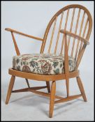 A retro original vintage Ercol light blond wood windsor pattern armchair  / lounge chair being