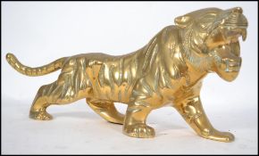 An original 20th century Chinese style brass Tiger figurine of large form in roaring pose.