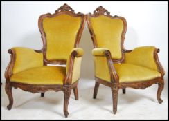 A pair of Victorian style mahogany armchairs of rococo form with decorative pierced and carved