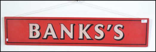 A vintage 20th century Banks Brewery enamel metal sign having white lettering on a red background.