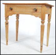 An Edwardian stripped pine being raised on square tapered legs with fitted frieze having single