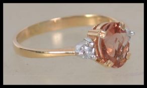 A 14ct yellow gold and citrine and diamond ring. The central citrine stone flanked by diamond